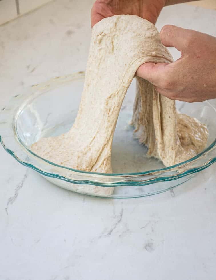 2 hands stretching dough
