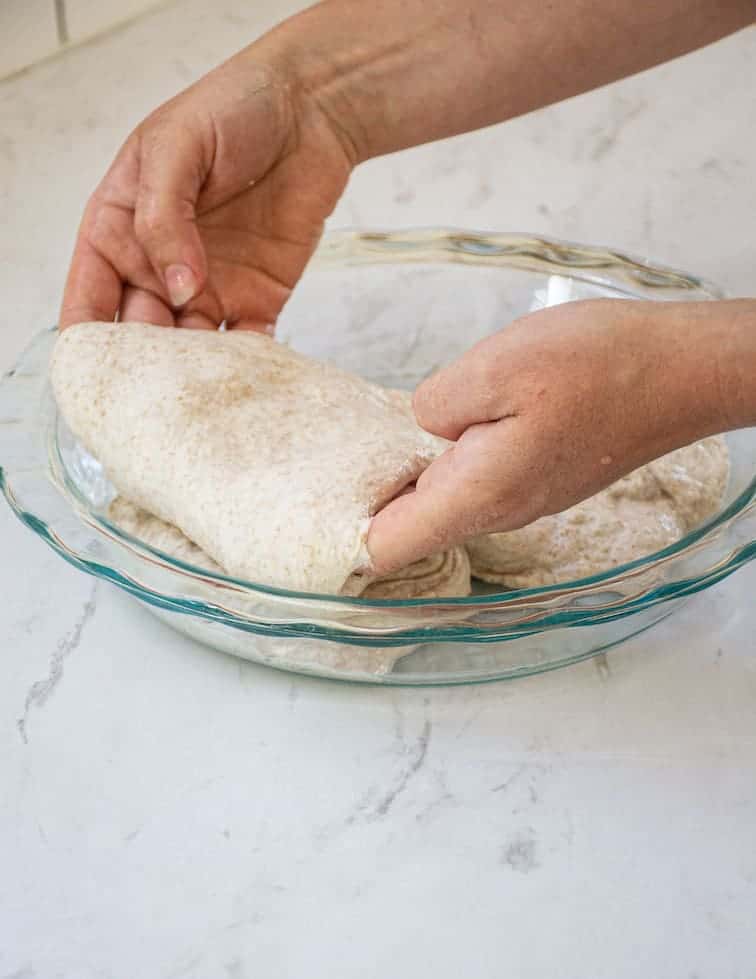 2 hands folding dough over
