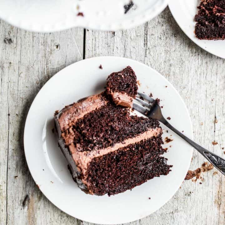 a slice of sourdough chocolate cake with a piece removed with a fork on a white plate