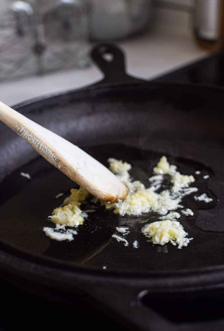 garlic frying in oil in a black pan 