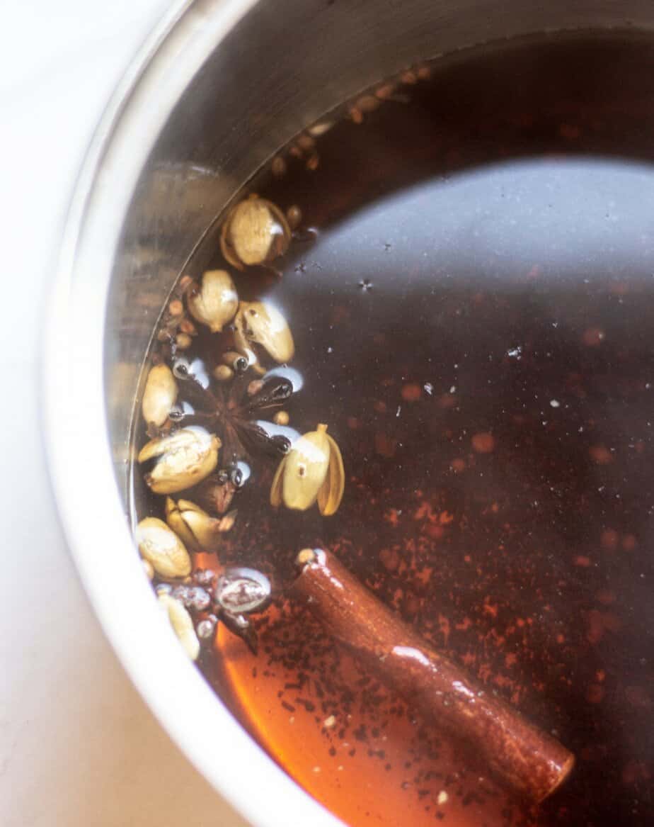 a silver pan of black tea and spices