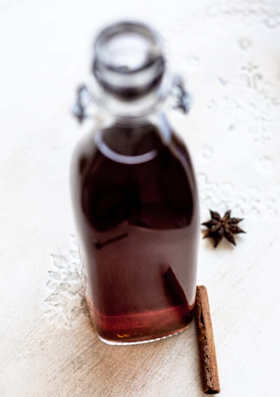 a bottle of chai syrup with a cinnamon stick and star anise in the background
