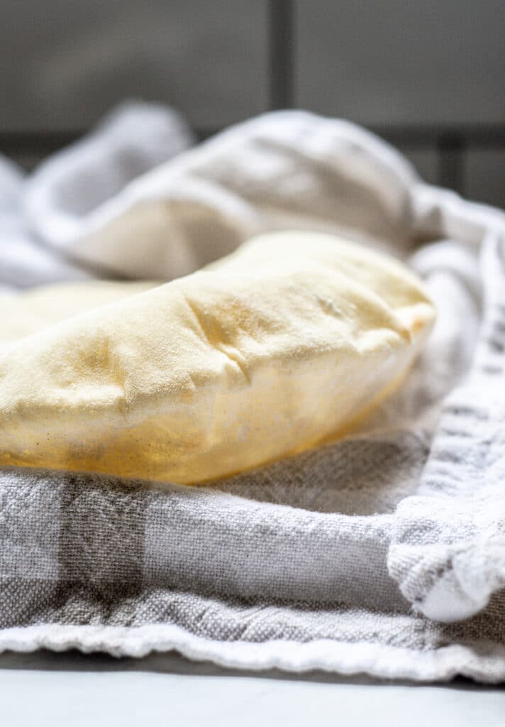 a close up of a sourdough pita bread on a kitchen towel