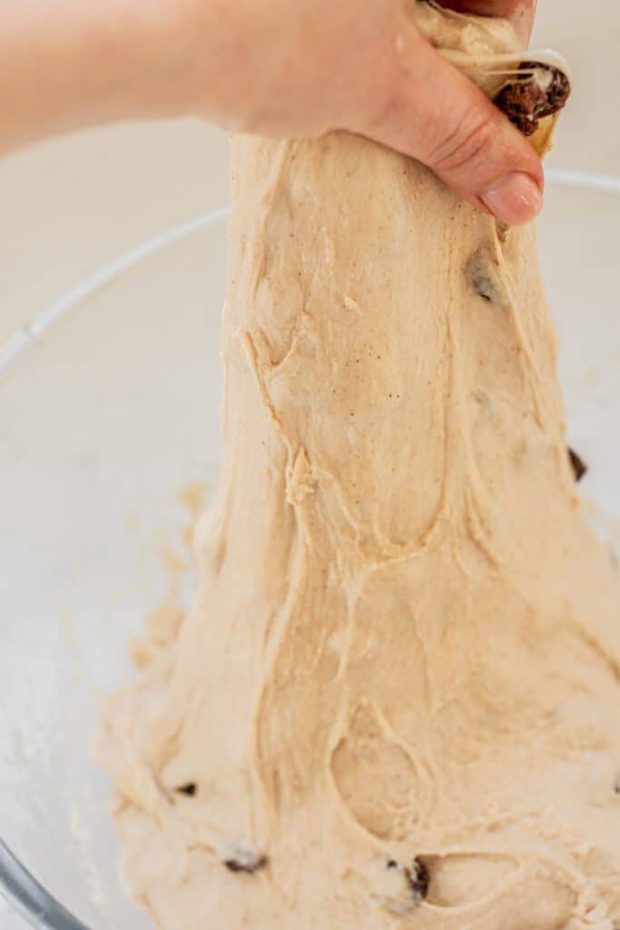 a hand stretching dough.