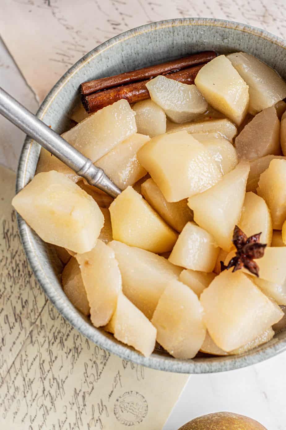 spoon in a bowl of pear chunks.