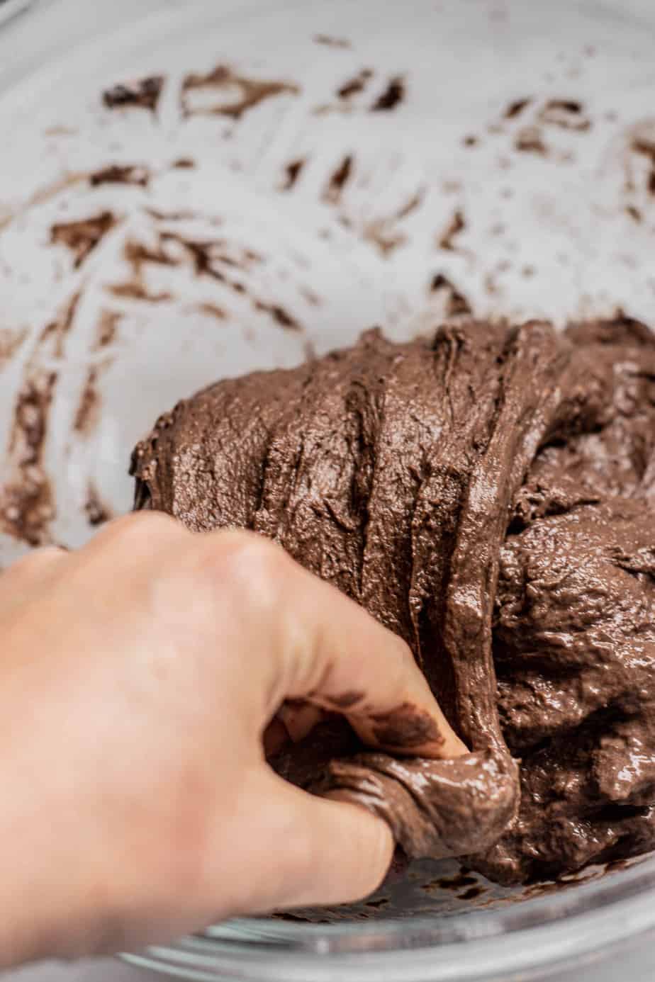 a hand folding chocolate dough.