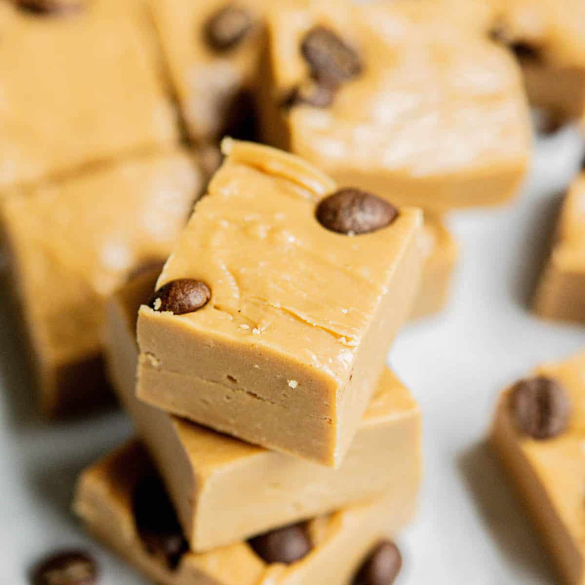 Stacked coffee fudge pieces with coffee beans on them.