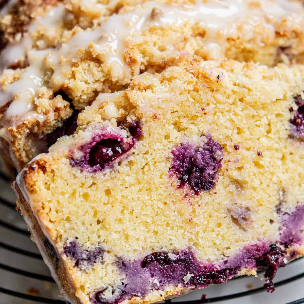 slice of blueberry cake with purple berries.