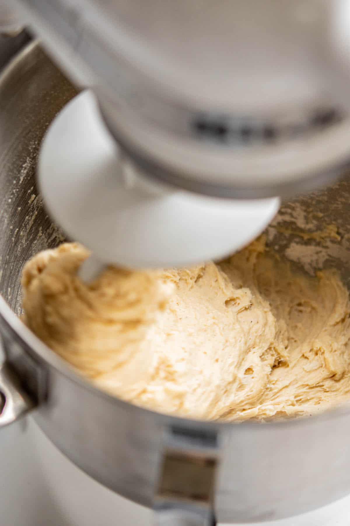 dough for doughnuts being mixed in stand mixer.
