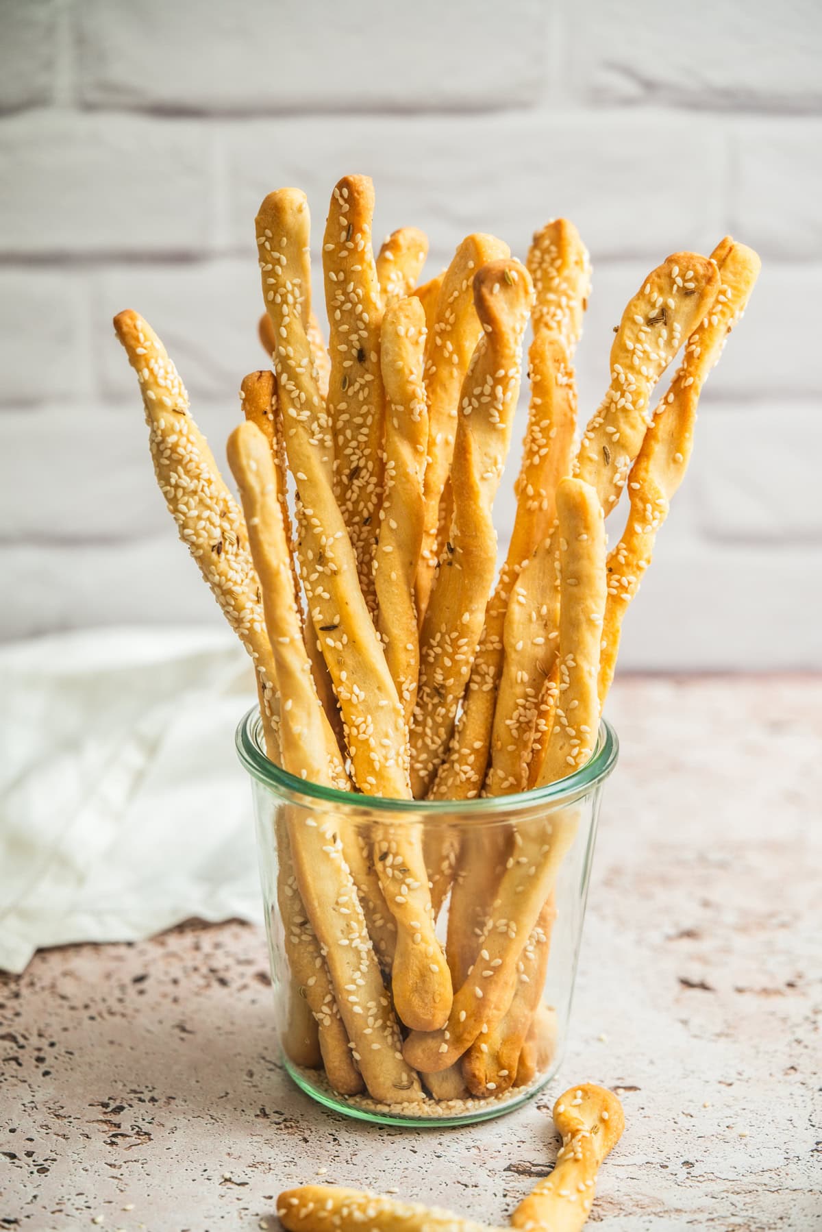 A glass jar full of bread sticks.